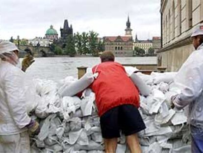 Voluntarios trabajan para crear muros de contención en el casco histórico de Praga.