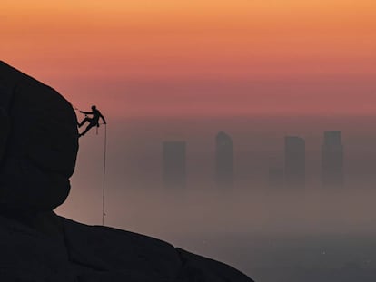 El bombero Antonio Marcos escala con las Cuatro Torres de fondo. Pincha sobre la imagen para ver más fotos de este 'skyline'.