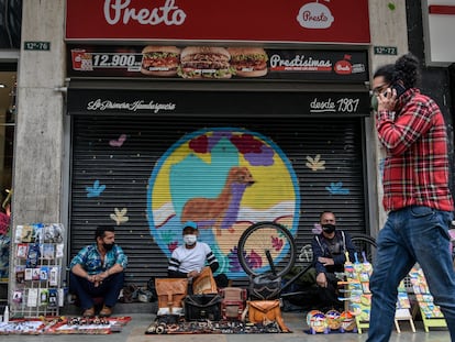 Artesanos y vendedores informales se sientan en un restaurante que tuvo que cerrar y quebró, en Bogotá, el 02 de julio de 2020.