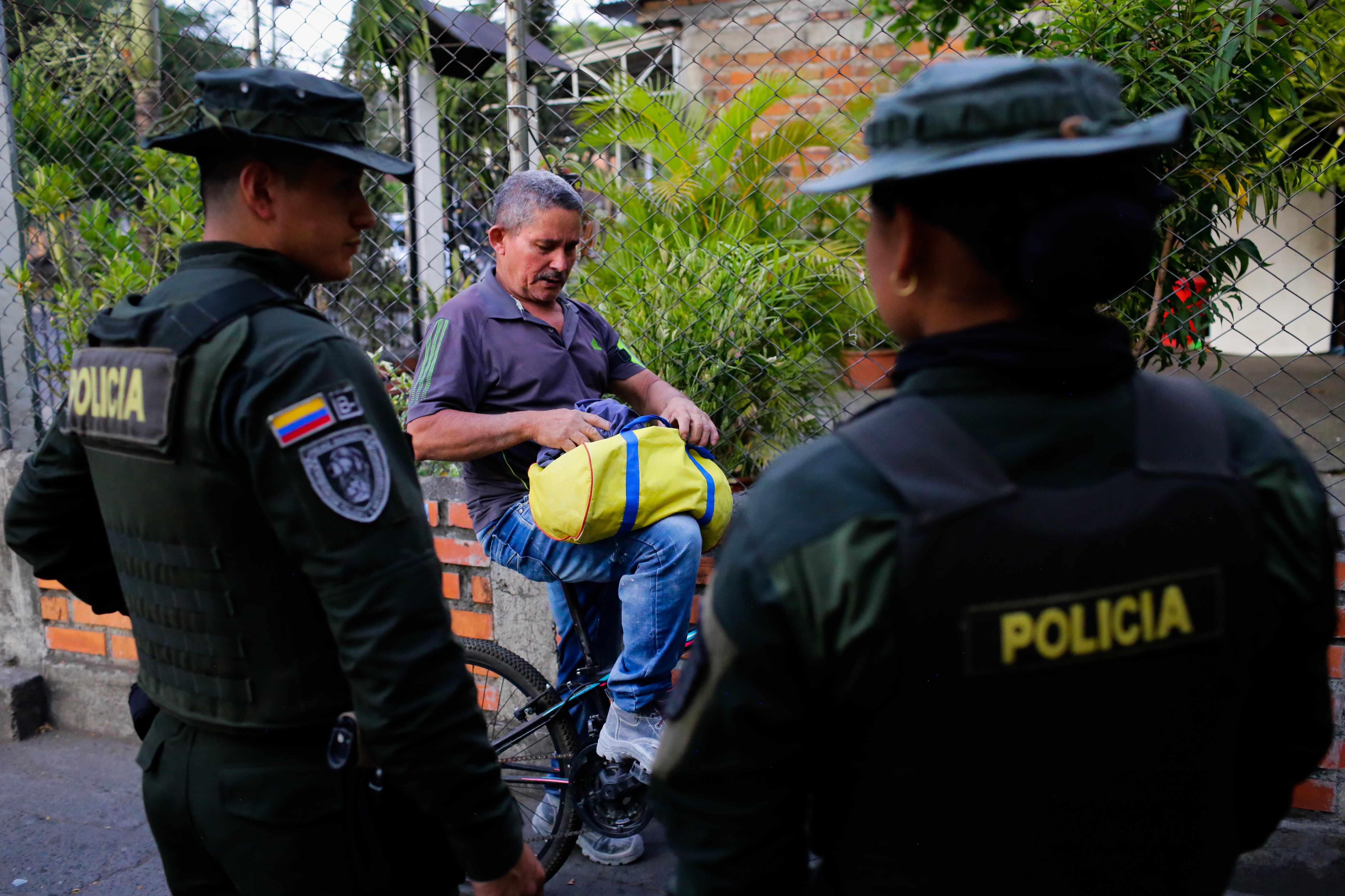 Policías inspeccionan las pertenencias de un hombre en las calles de Tuluá, el 14 de febrero.