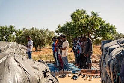 Migrantes musulmanes rezan en un campamento.