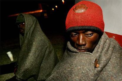 Uno de los inmigrantes descansa en el muelle de Fuerteventura tras ser atendido por Cruz Roja.