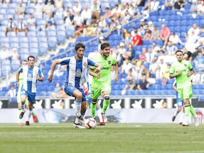 Granero conduce el balón con Campaña, del Levante, al lado.