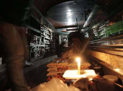 Un comercio  iluminado por una vela durante el racionamiento eléctrico, en el área metropolitana de Caracas.