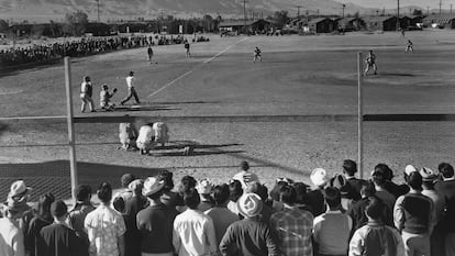 UNITED STATES - CIRCA 1943: Japanese Americans observe an amateur baseball game in progress; one-story buildings and mountains in the background. Ansel Easton Adams (1902 1984) was an American photographer, best known for his black-and-white photographs of the American West. During part of his career, he was hired by the US Government to record life in the West. (Photo by Buyenlarge/Getty Images)