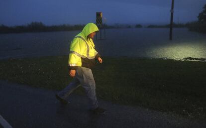Un miembro de la tripulación del Departamento de Transporte de Alabama pasa por un estacionamiento inundado en la autopista 98,  parcialmente cerrada por la tormenta tropical Gordon. 