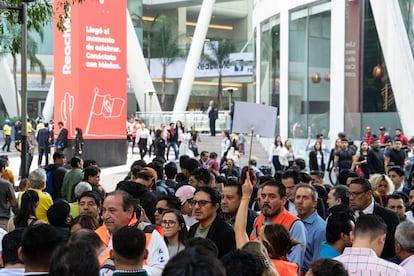 Cientos de personas se forman en filas para evacuar el centro comercial. 