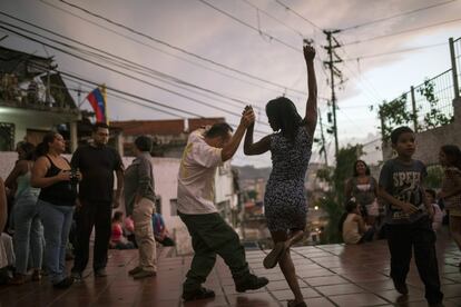 Irene Vaamondez, a la derecha, baila con un vecino al ritmo de la música en vivo en una plaza pública en el barrio La Concepción en Caracas (Venezuela), el 11 de mayo de 2019. A más de 15 días del levantamiento militar liderado por Leopoldo López y Juan Guaidó, el país petrolero permanece en tensión con miras a solucionar la crisis política con un nuevo intento de diálogo; mientras la inflación, los cortes de luz y la escasez de medicinas y alimentos continúan debilitando la estabilidad social de la población.