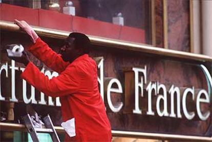 Un inmigrante en Francia limpia una fachada.