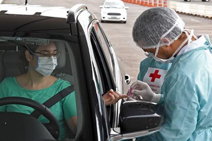 Un trabajador sanitario le hace un test rápido de coronavirus a una mujer en Brasilia (Brasil), el 21 de abril.