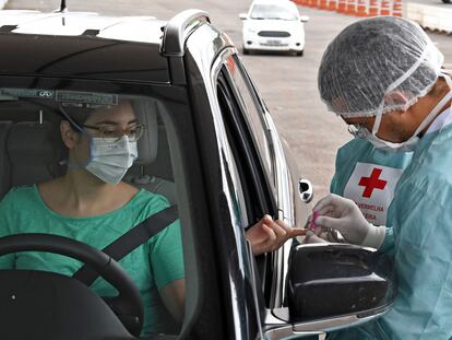 Un trabajador sanitario le hace un test rápido de coronavirus a una mujer en Brasilia (Brasil), el 21 de abril.