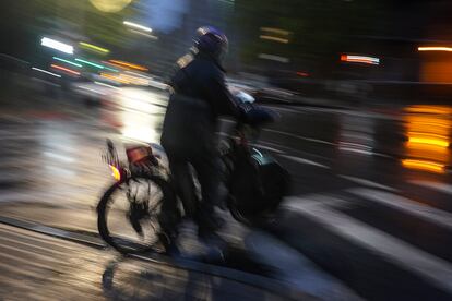 A food delivery worker rides in the night along Brooklyn's Bedford Avenue