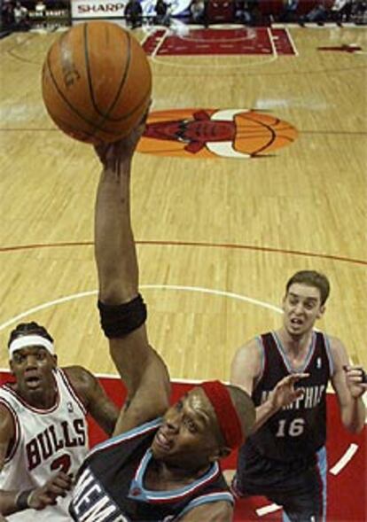 El jugador de los Grizzlies Bonzi Wells, a punto de encestar ante a mirada de Pau Gasol.