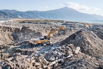 Excavators dig through the rubble of buildings destroyed by the earthquake in Samandağ, in the Hatay province, looking for metals to sell as scrap.