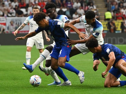 Tyler Adams, de EE UU, luchaba por mantener el balón en su poder ante los ingleses Bukayo Saka y Jude Bellingham, este viernes en Doha.