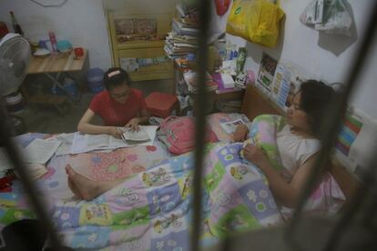 Muchos estudiantes se desplazan junto a sus familias para poder recibir la intensa preparación que les puede asegurar una buena cualificación en la Escuela Secundaria de Maotanchang. En la foto, una estudiante realiza sus deberes en la cama al lado de su madre en una habitación alquilada cerca de la Escuela Secundaria Maotanchang, el 2 de junio del 2017 en Luan.