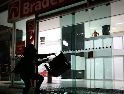 Manifestante depreda uma agência bancária no centro de São Paulo.