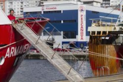 Entre unos barcos de pesca del Puerto de Vigo la nave de fr&iacute;o de Pescanova, en la avenida de Beiramar.