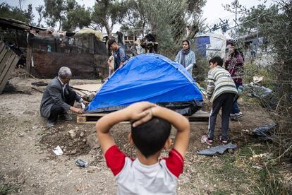 Pese al endurecimiento de las leyes de asilo del nuevo Gobierno de derechas del país, los refugiados siguen llegando a diario. En la imagen, un niño observa a varios miembros de su familia instalando su tienda de campaña.
