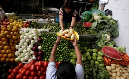 Una mujer compra verduras y hortalizas en un mercado de Ciudad de México.