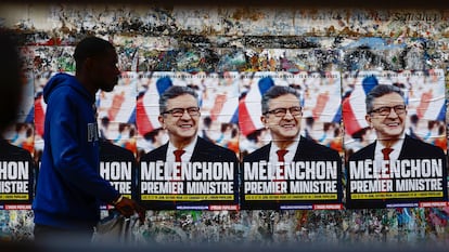 Un hombre pasa por delante de unos carteles del candidato de La Francia Insumisa, Jean-Luc Mélenchon, en una calle de Paris.