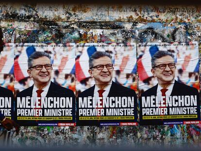 Un hombre pasa por delante de unos carteles del candidato de La Francia Insumisa, Jean-Luc Mélenchon, en una calle de Paris.