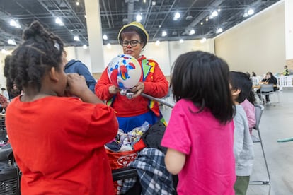 Una mujer entretiene a los niños en el Centro de Convenciones de Pasadena, el mayor refugio temporal para afectados por el incendio de Pasadena, Los Ángeles, California.