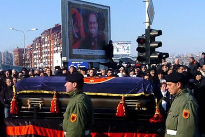 Ciudadanos kosovares observan el paso del ataúd durante el funeral del presidente de Kosovo.