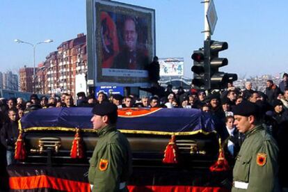 Ciudadanos kosovares observan el paso del ataúd durante el funeral del presidente de Kosovo.