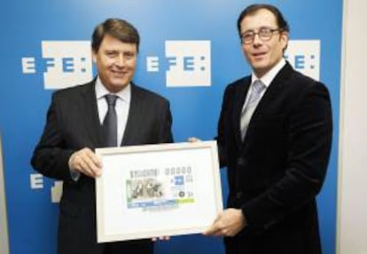 El delegado territorial de la ONCE en Castilla y León, Ismael Pérez Blanco (d), entrega al delegado general de Efe en Castilla y León, Pedro Damián de Diego, el cupón del sorteo extraordinario del 1 de febrero.