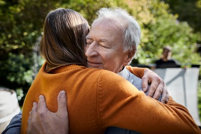 Senior man and young woman hugging in garden