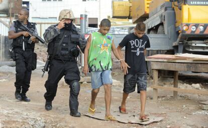 Policías escoltan a dos detenidos en una favela de Río