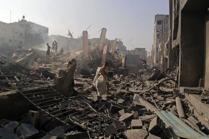 En esta foto de archivo del sábado 2 de agosto de 2014, varios palestinos examinan los escombros de las casas destruidas en un ataque israelí en Rafah, al sur de la Franja de Gaza. El ejército israelí dijo el miércoles 15 de agosto de 2018 que su investigación se centró en una batalla del 1 de agosto de 2014 en el pueblo de Rafah, en el sur de Gaza, uno de los incidentes más sangrientos de la guerra de 2014, y no encontró ningún delito criminal por parte de las fuerzas israelíes. Los defensores de derechos humanos han acusado a los militares de encubrimiento.