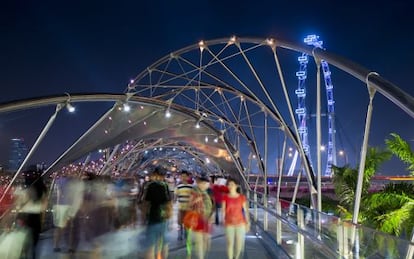 Turistas cruzando Helix bridge, en la zona de Marina Bay, en Singapur.