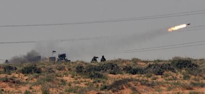 Rebeldes libios disparan un cohete contra las fuerzas leales a Gadafi cerca de Bin Yauad.