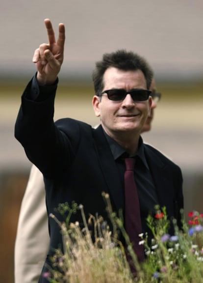 Charlie Sheen saluda a los fotógrafos a su llegada a la audiencia ante el juez el 2 de agosto de 2010