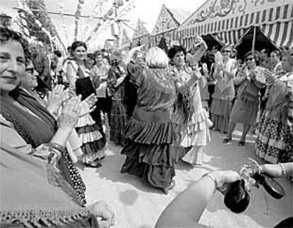 Un grupo de mujeres baila sevillanas.