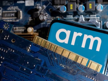 Logo de Arm en un teléfono móvil junto a circuitos impresos.