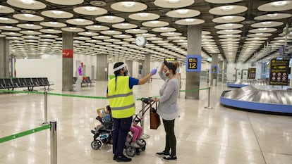 A traveler arriving in Madrid's Barajas Airport last summer has her temperature checked.