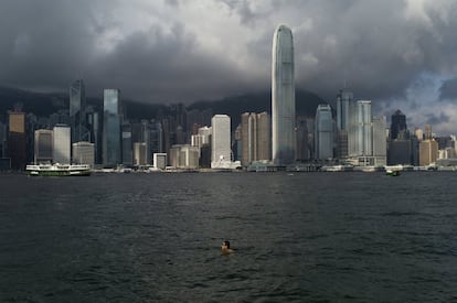 Un hombre nada en las aguas contaminadas del puerto Victoria Harbour de Hong Kong (China).