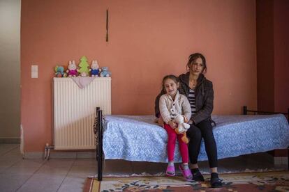 Zeina, refugiada siria, con su hija Turli, en su casa de Livadiá (Grecia).