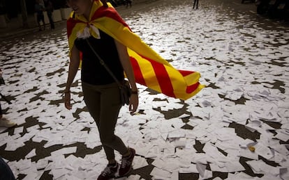 Una mujer vestida con la "estelada" camina sobre papeletas de voto tras la consulta del 1 de octubre.