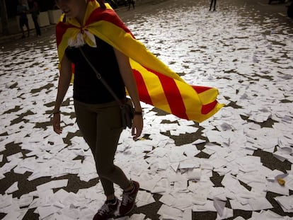 Una mujer vestida con la "estelada" camina sobre papeletas de voto tras la consulta del 1 de octubre.