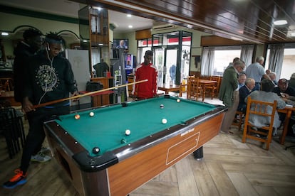 Algunos de los inmigrantes recibidos en Monterroso juegan al billar en un bar del pueblo.