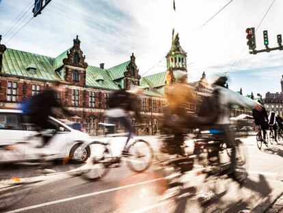 Ciclistas en Copenhague, con el edificio de la Bolsa al fondo.