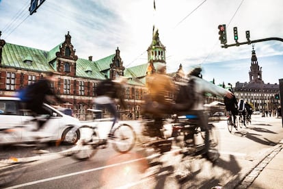 Ciclistas en Copenhague, con el edificio de la Bolsa al fondo.
