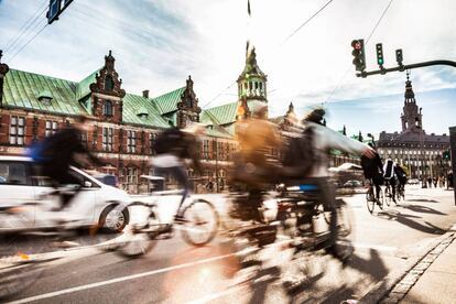 Ciclistas en Copenhague, con el edificio de la Bolsa al fondo.