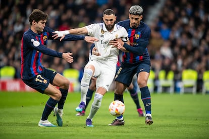 Karim Benzema disputa el balón a los jugadores del Barcelona Araujo ( D ) y Marcos Alonso ( I )