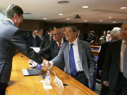 El presidente de Bankia, José Ignacio Goirigolzarri, saluda al expresidente de Kutxabank, Mario Fernández.