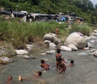 Un grupo de niños juega en el arroyo cercano al asentamiento.